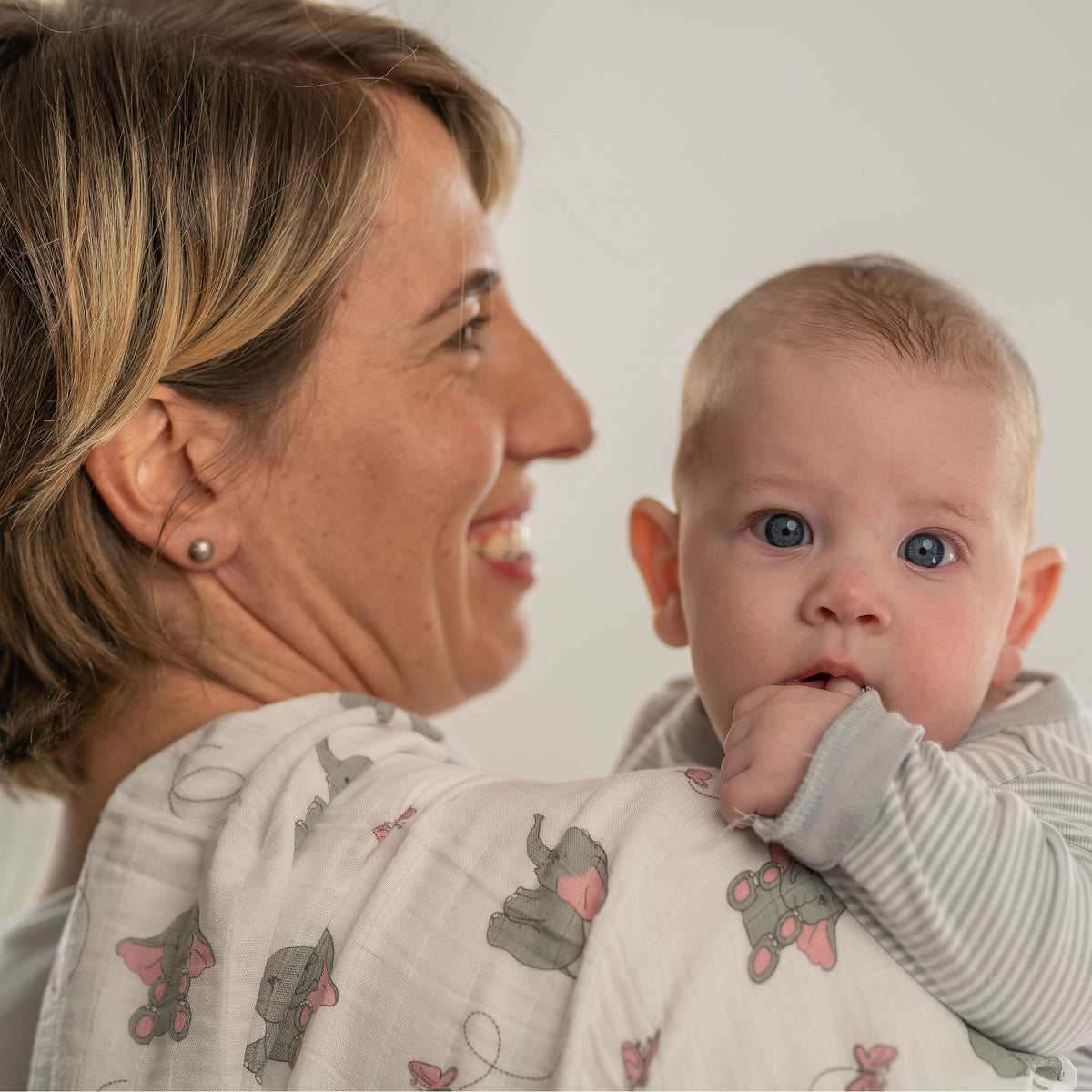 Mutter mit Baby auf dem Arm, eine Tabalino Mullwindel Rosa Elefanten über der Schulter